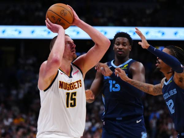Nikola Jokic (kiri) membukukan triple-double saat Denver Nuggets mengalahkan tim tamu Memphis Grizzlies 117-109 pada Jumat (11/4) malam. (Foto: AP)