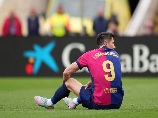 Robert Lewandowski terduduk dan tak bisa melanjutkan pertandingan pasca mengalami cedera paha pada saat memperkuat Barcelona melawan Celta Vigo (19/4) / via Getty Images