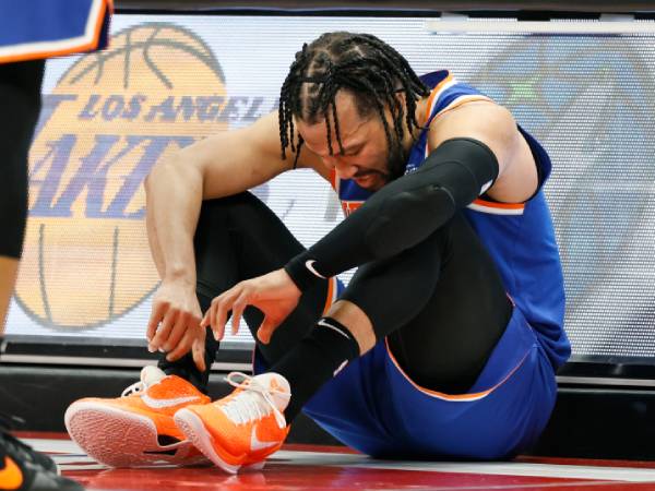 Jalen Brunson terlihat duduk bersandar di meja pencatatan skor saat mengalami cedera pergelangan kaki. (Foto: AP)