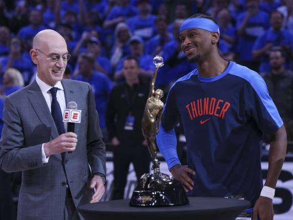Shai Gilgeous-Alexander (kanan) menerima Piala Michael Jordan dalam upacara penyerahan trofi MVP dari Komisioner NBA Adam Silver. (Foto: AP)