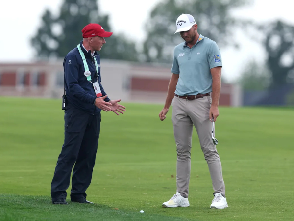 Sam Burns (kanan) dan seorang ofisial aturan berdisikusi soal kondisi lapangan. (Foto: Golf Digest)