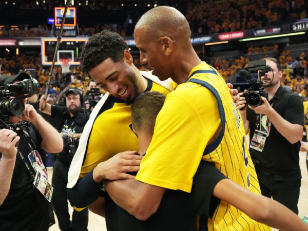 Bintang Indiana Pacers Tyrese Haliburton (kiri) memeluk legenda Reggie Miller dan putranya usai memenangi Game 6. (Foto: AP)
