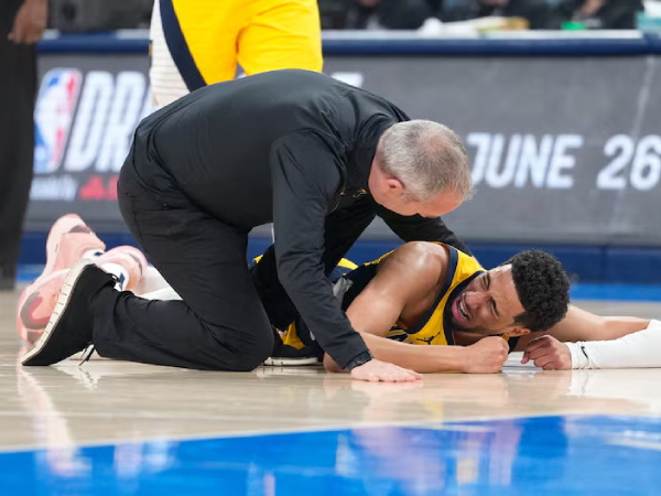 Tyrese Haliburton terbaring menjerit kesakitan saat staf pelatih menghampirinya. (Foto: AP)