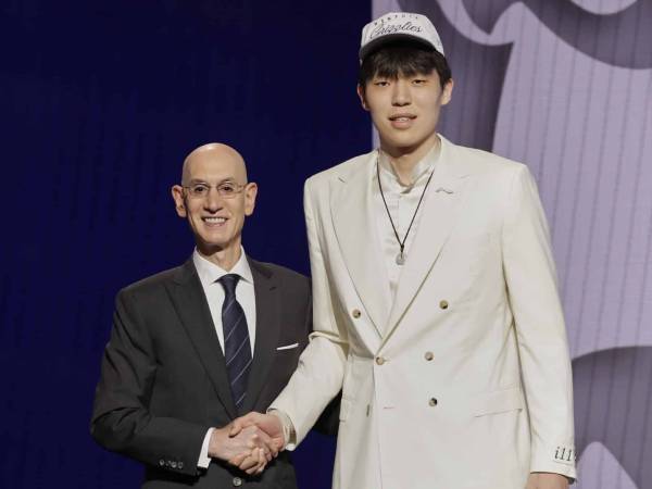 Yang Hansen (kanan) berjabat tangan dengan Komisioner Adam Silver setelah diumumkan sebagai pilihan ke-16 di Draft NBA 2025. (Foto: AP)