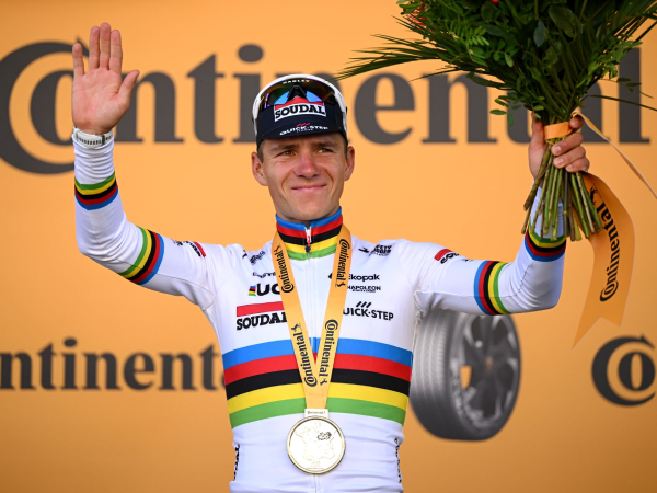 Remco Evenepoel melakukan selebrasi di atas podium setelah memenangi etape kelima time trial Tour de France 2025. (Foto: AFP)
