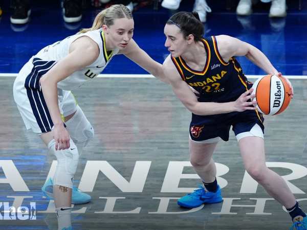 Caitlin Clark (kanan) berduel dengan Paige Bueckers saat Indiana Fever mengalahkan Dallas Wings 102-83 pada Minggu (13/7) di Indianapolis. (Foto: AP)