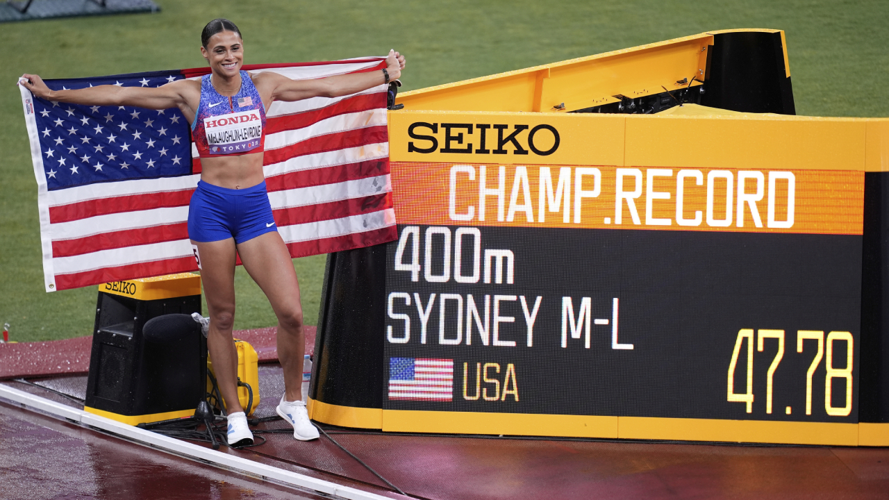 Sydney McLaughlin-Levrone berpose di sebalah papan pencatat rekor setelah memenangi nomor lari 400 meter di Tokyo. (Foto: AP)