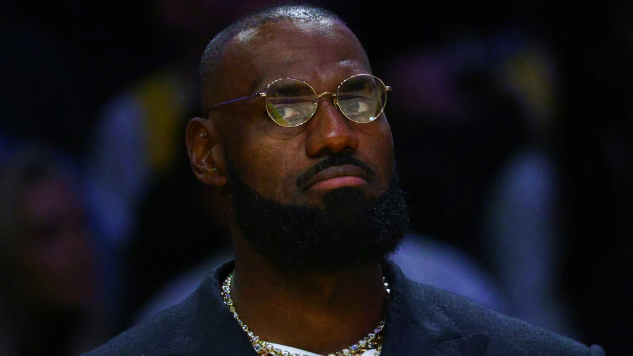 Selama pertandingan pembuka di San Francisco pada Selasa (21/10), LeBron James duduk di bangku cadangan mengenakan setelan jas yang rapi. (Foto: AP)