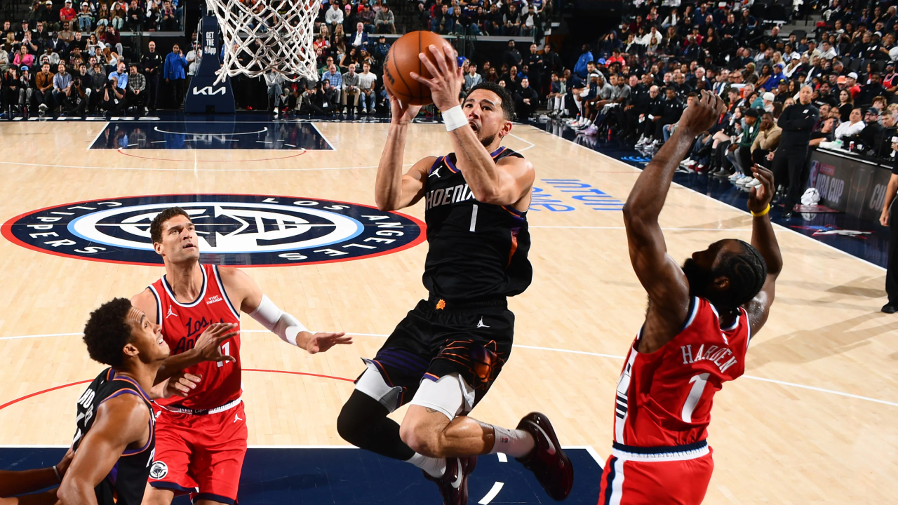Devin Booker (tengah) nyaris menghasilkan triple-double saat Phoenix Suns meraih kemenangan atas Los Angeles Clippers dengan skor 114-103 pada Sabtu (8/11) malam. (Foto: AP)