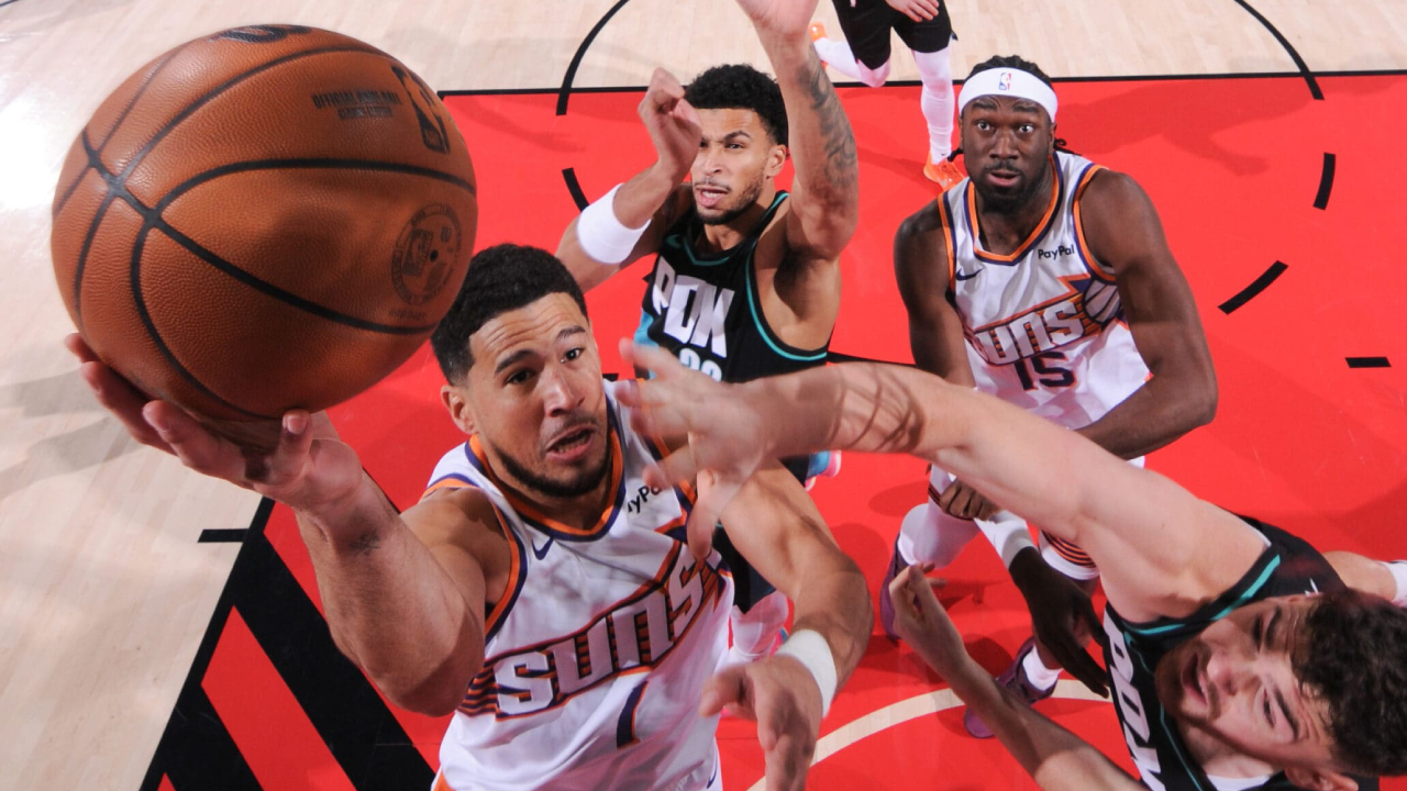 Devin Booker (kiri) mencetak 19 poin saat Phoenix Suns meraih kemenangan 127-110 atas tuan rumah Portland Trail Blazers pada Selasa (18/11) malam. (Foto: AP)