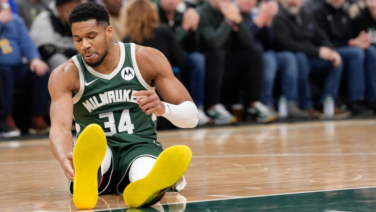 Giannis Antetokounmpo tampak memegangi bagian bawah kaki kanannya sebelum dibantu keluar lapangan dan langsung menuju ruang ganti. (Foto: AP)