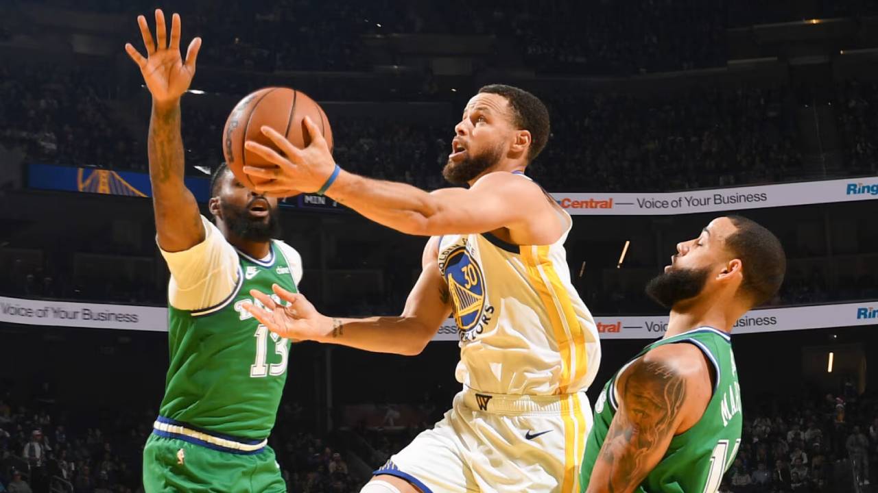 Stephen Curry (tengah) mencetak 23 poin saat Golden State Warriors mengalahkan Dallas Mavericks 126-116 pada Kamis (25/12) sore di San Francisco. (Foto: AP)