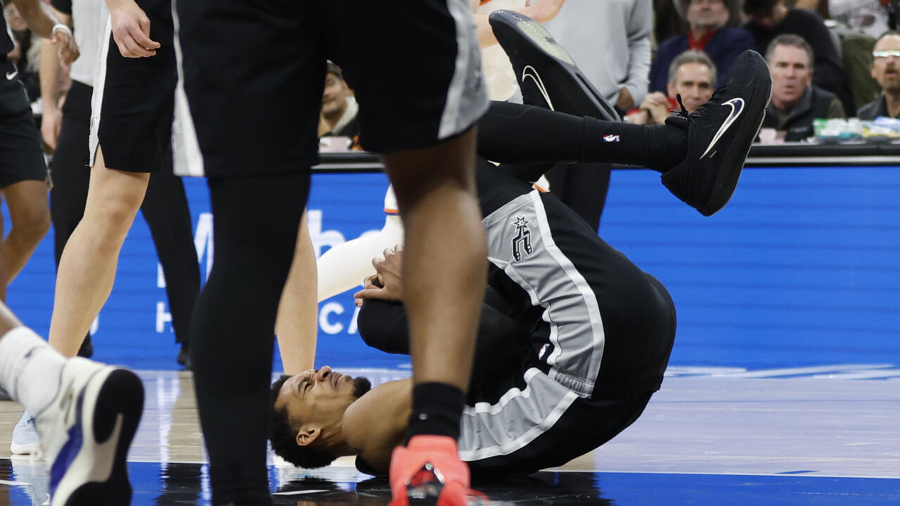 Saat mendarat, lutut kirinya terlihat tertekuk, dan Victor Wembanyama langsung memegangi bagian tersebut sambil menunjukkan rasa tidak nyaman. (Foto: AP)