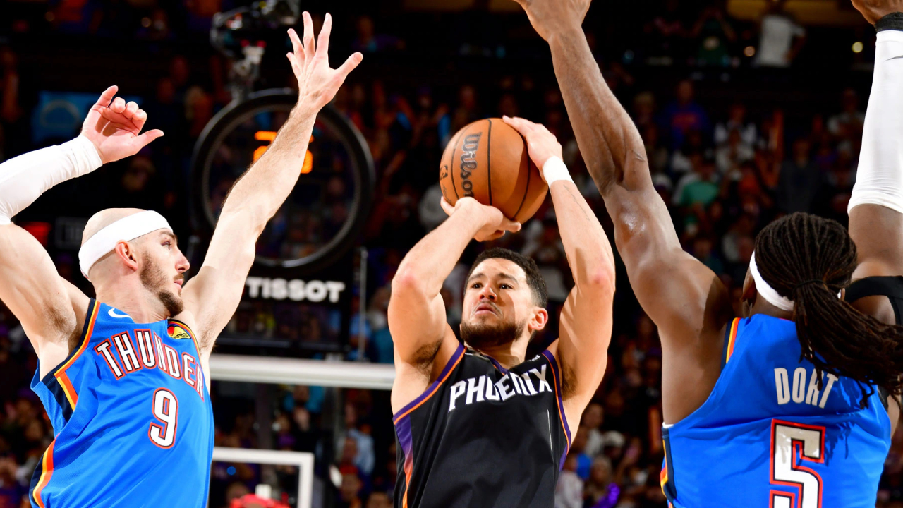Devin Booker (tengah) melesakkan tembakan penentu kemenangan saat Phoenix Suns menumbangkan Oklahoma City Thunder 108-105 pada Minggu (4/1) malam waktu setempat. (Foto: AP)