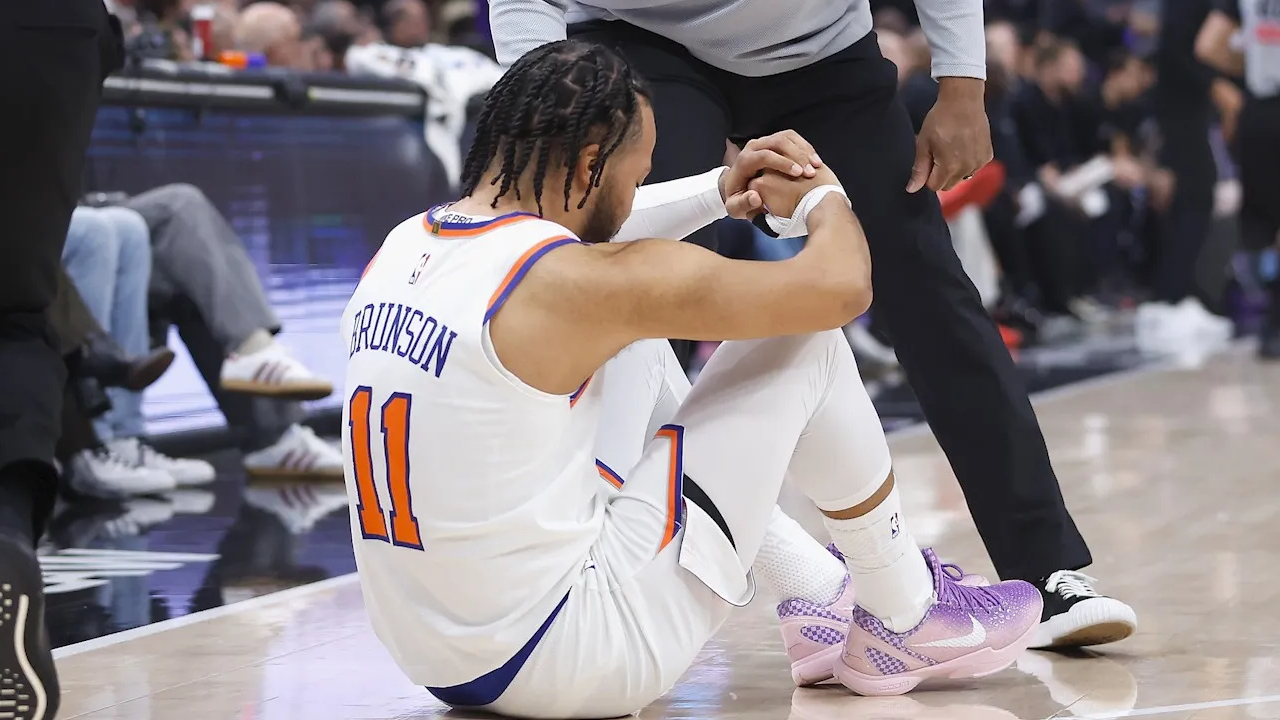 Jalen Brunson duduk di lantai setelah mengalami cedera engkel di kuarter pertama versus Kings. (Foto: AP)