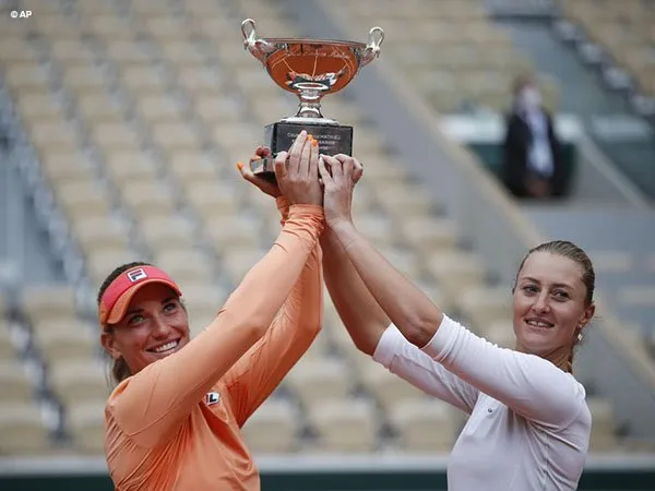 Timea Babos [kiri] dan Kristina Mladenovic [kanan] berpose dengan trofi French Open 2020