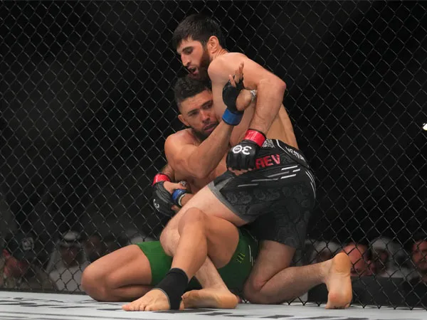 Magomed Ankalaev (kanan) melakukan tendangan lutut illegal ke kepala Johnny Walker, yang berbuntut dihentikannya laga tersebut oleh wasit. (Foto: Yahoo)
