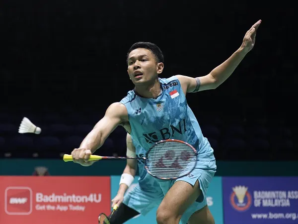 Fajar Alfian melakukan smash dalam pertandingan bulu tangkis