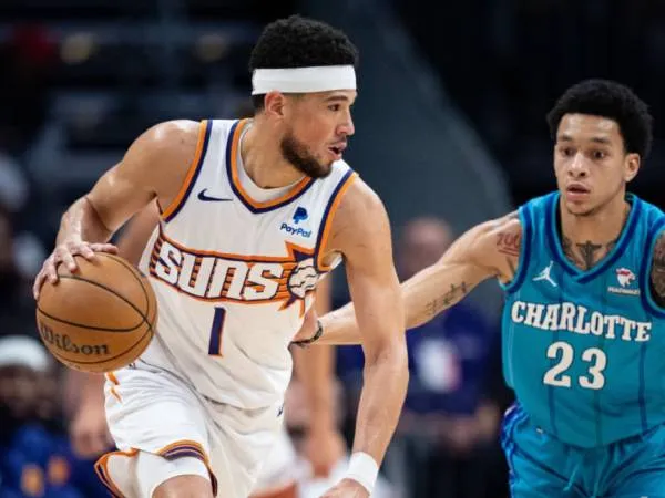 Devin Booker (kiri) mencetak 21 poin dan 11 assist saat Phoenix Suns mengalahkan Charlotte Hornets 107-96 pada Jumat (15/3) malam. (Foto: AP)