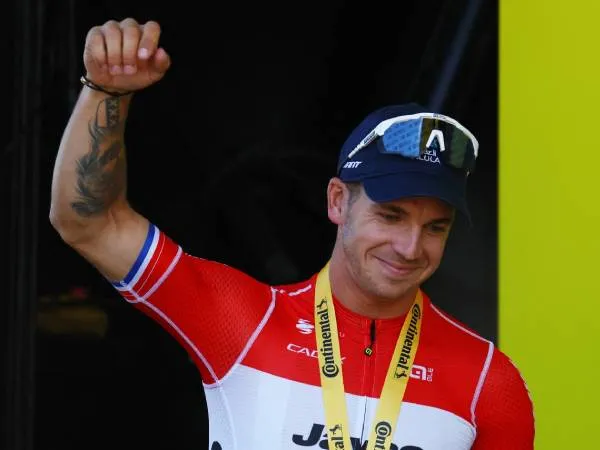 Dylan Groenewegen melakukan selebrasi di atas podium sebagai pemenang etape keenam Tour de France 2024 pada Kamis (4/7). (Foto: AFP)