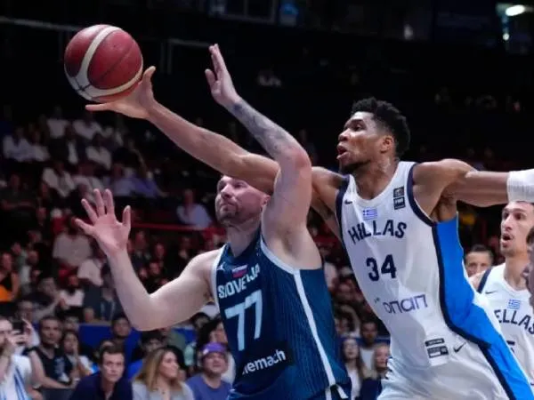 Giannis Antetokounmpo (kanan) dari Yunani menghadang usaha Luka Doncic dari Slovenia dalam babak semifinal turnamen kualifikasi Olimpiade di Piraeus, Sabtu (6/7). (Foto: AP)