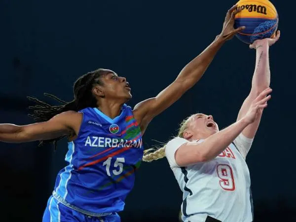 Pemain Azerbaijan Tiffany Hayes (kiri) memblok tembakan pemain AS Hailey Van Lith dalam pertandingan penyisihan grup bola basket 3x3 putri Olimpiade Paris pada Rabu (31/7). (Foto: AP)