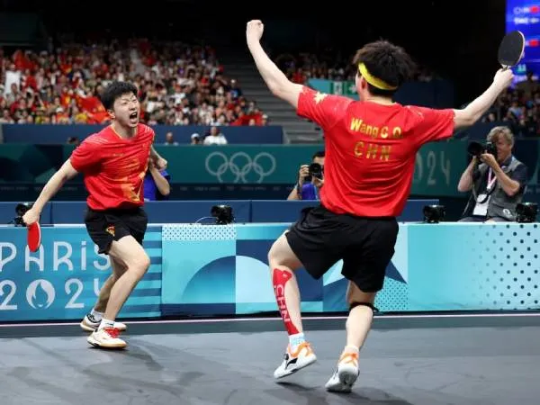 Ma Long (kiri) dan Wang Chuqin melakukan selebrasi setelah memastikan kemenangan China dalam final beregu tenis meja putra di Olimpiade Paris pada Jumat (9/8). (Foto: Xinhua)