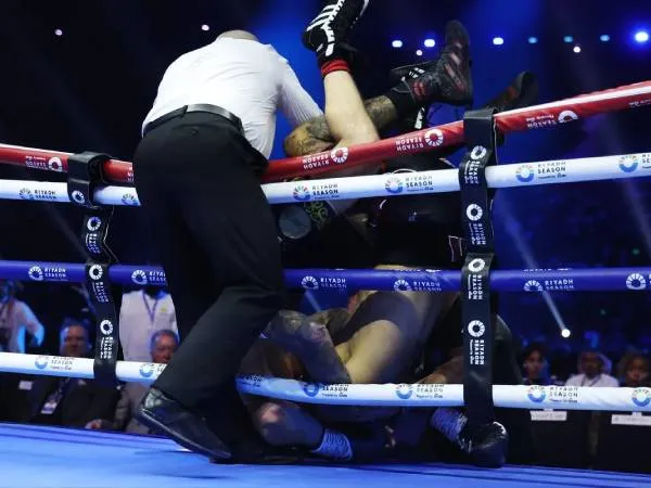 Ben Whittaker dan Liam Cameron terjatuh keluar ring di akhir ronde kelima. (Foto: AP)