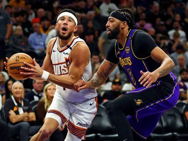 Devin Booker (kiri) mencetak 33 poin saat tuan rumah Phoenix Suns meraih kemenangan 109-105 atas Los Angeles Lakers pada Senin (28/10) malam. (Foto: AP)