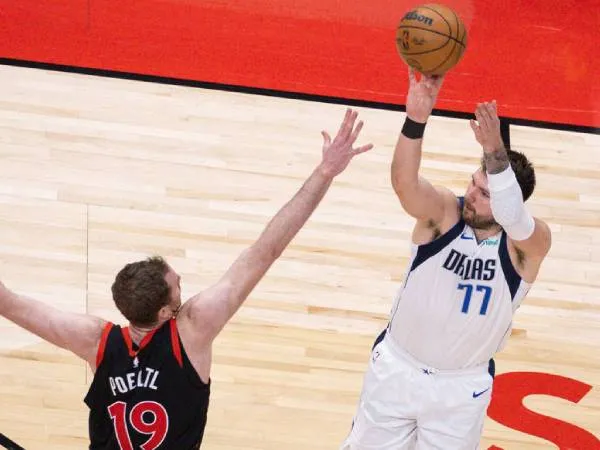 Luka Doncic (kanan) mencetak triple-double saat Dallas Mavericks mengalahkan Toronto Raptors 125-118 pada Sabtu (7/12) malam. (Foto: AP)