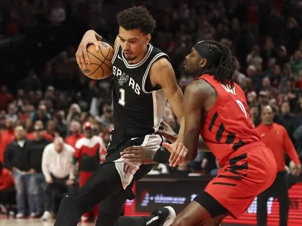 Victor Wembanyama (kiri) mencetak 28 poin saat San Antonio Spurs meraih kemenangan 118-116 atas Portland Trail Blazers pada Jumat (13/12) malam. (Foto: AP)