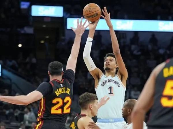 Victor Wembanyama (tengah) mencetak 42 poin saat San Antonio Spurs mengalahkan tim tamu Atlanta Hawks 133-126 lewat perpanjangan waktu pada Kamis (19/12) malam. (Foto: AP)