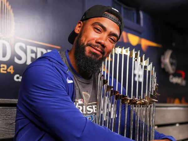 Teoscar Hernandez berpose dengan trofi World Series setelah membantu Dodgers memenanginya musim lalu. (Foto: AP)