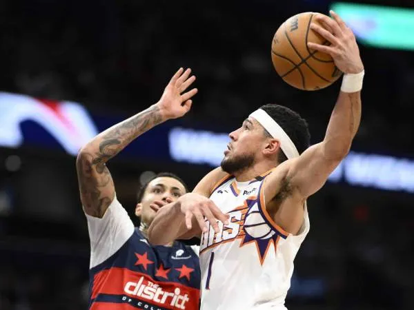 Devin Booker (kanan) mencetak 37 poin saat Phoenix Suns meraih kemenangan 130-123 atas Wizards pada hari Kamis (16/1) malam. (Foto: AP)