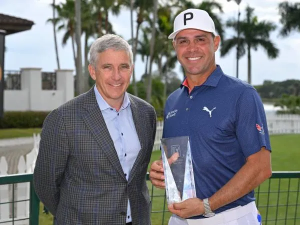 Gary Woodland (kanan) berpose dengan komisaris PGA Tour Jay Monahan sambil memegangi trofi PGA Tour Courage Award. (Foto: Golf Digest)