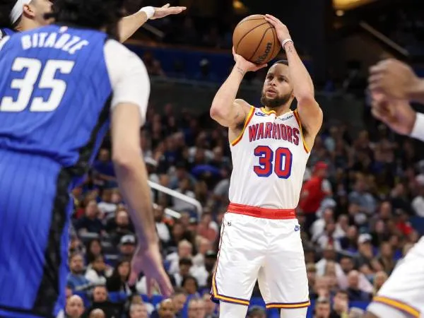 Steph Curry (kanan) mencetak 56 poin saat Golden State Warriors mengalahkan tuan rumah Orlando Magic 121-115 pada Kamis (27/2) malam. (Foto: AP)
