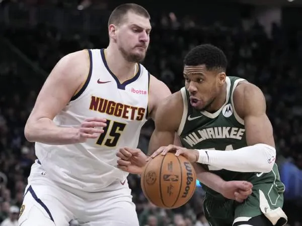 Giannis Antetokounmpo (kanan) mencetak 28 poin saat Milwaukee Bucks meraih kemenangan 121-112 atas tim tamu Denver Nuggets pada Kamis (27/2) malam. (Foto: AP)