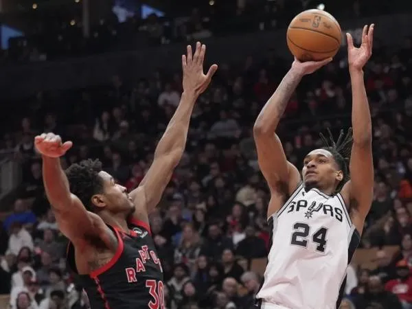 Devin Vassell (kanan) mencetak 25 poin saat tim tamu San Antonio Spurs mendominasi Toronto Raptors 123-89 pada hari Minggu (22/3) malam. (Foto: AP)