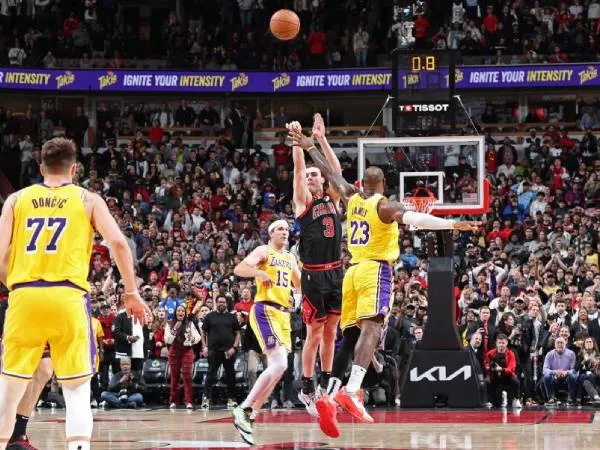Josh Giddey (tengah) melesakkan tembakan penentun kemenangan dari tengah lapangan saat Chicago Bulls mengalahkan Los Angeles Lakers 119-117 pada Kamis (27/3) malam. (Foto: AP)