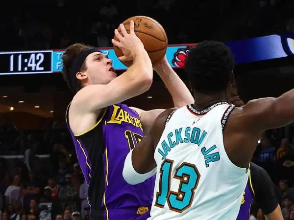 Austin Reaves (kiri) membukukan 31 poin saat Los Angeles Lakers meraih kemenangan 134-127 atas tuan rumah Memphis Grizzlies pada Sabtu (29/3) malam. (Foto: AP)