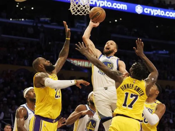 Stephen Curry (tengah) mencetak 37 poin saat tim tamu Golden State Warriors menang 123-116 atas Los Angeles Lakers, Kamis (3/4) malam. (Foto: AP)