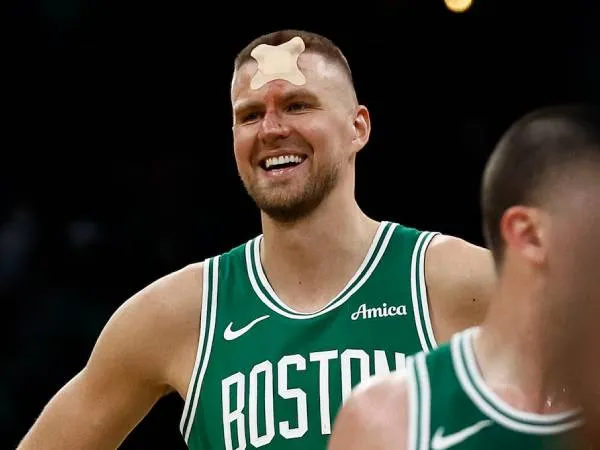 Kristaps Porzingis tersenyum meski dahinya diperban karena mendapat luka lima jahitan. (Foto: AP)