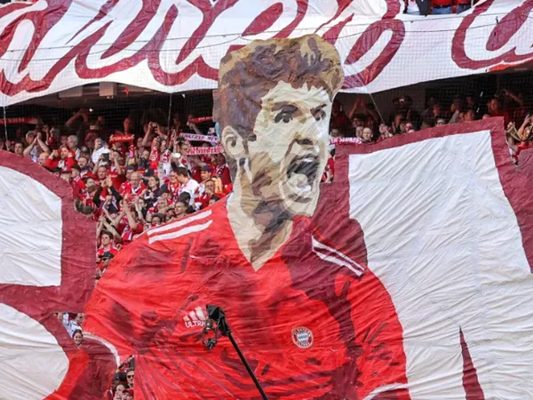 Momen Saat Suporter Bayern Munich Membentangkan Banner Berwajah Thomas Muller (Sumber: Marcel Engelbrecht - firo sportphoto/Getty Images)