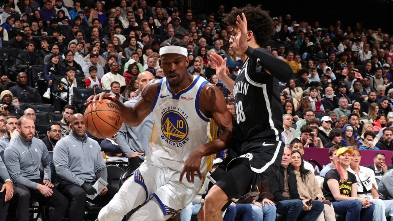 Jimmy Butler (kiri) mencetak 21 poin saat Golden State Warriors meraih kemenangan 120-107 atas Brooklyn Nets pada laga Senin (29/12).