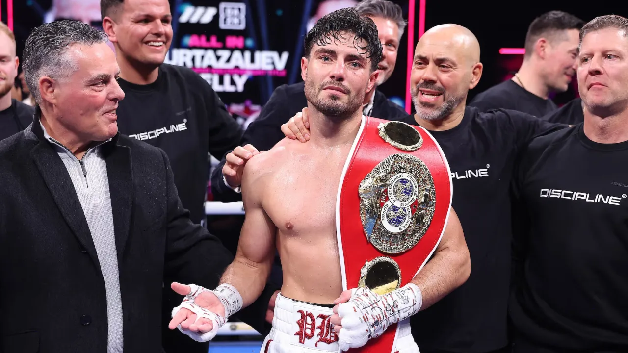 Josh Kelly (tengah) berpose dengan sabuk barunya sembari dikelilingi timnya. (Foto: Fight TV)