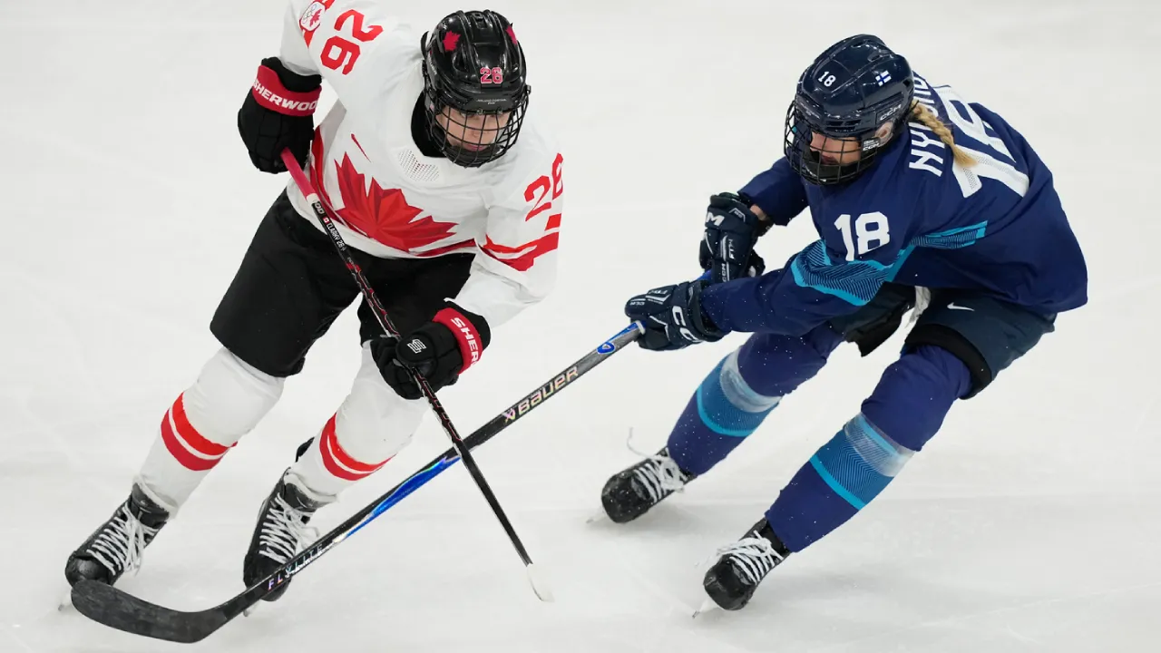 Penyerang tim hoki es putri Kanada Emily Clark (kiri) berduel dengan seorang pemain Finlandia. (Foto: AP)