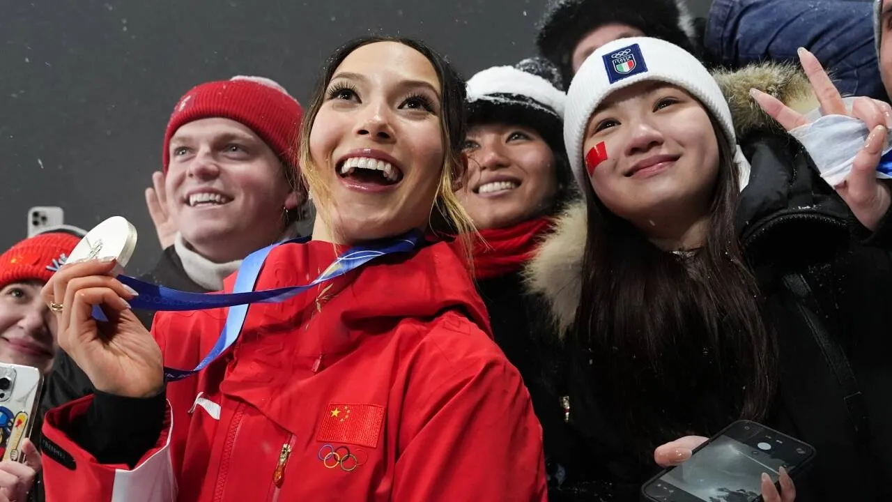 Gu Ailing (kiri) berpose dengan fans setelah meraih medali perak nomor freeski big air putri. (Foto: AP)