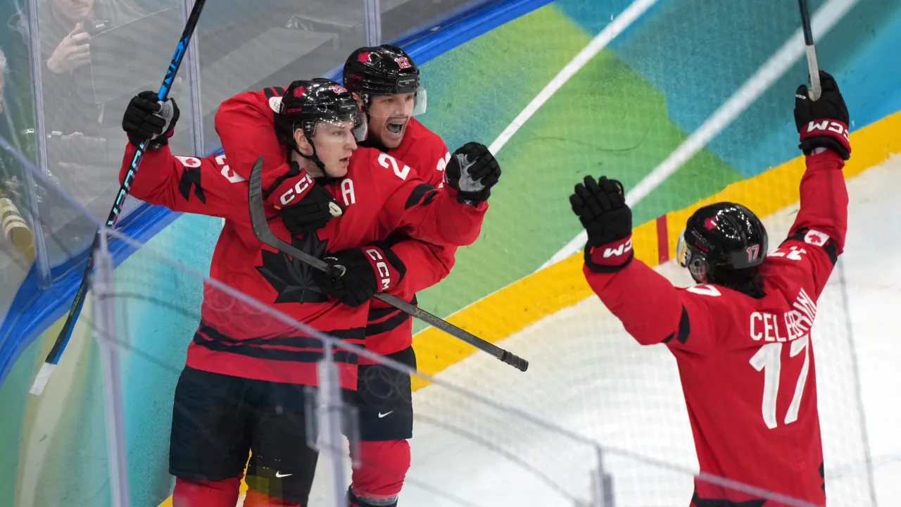 Nathan MacKinnon (kiri) dipeluk rekan setimnya setelah memastikan kemenangan Kanada atas Finlandia di semifinal hoki es putra Olimpiade Musim Dingin 2026. (Foto: AP)