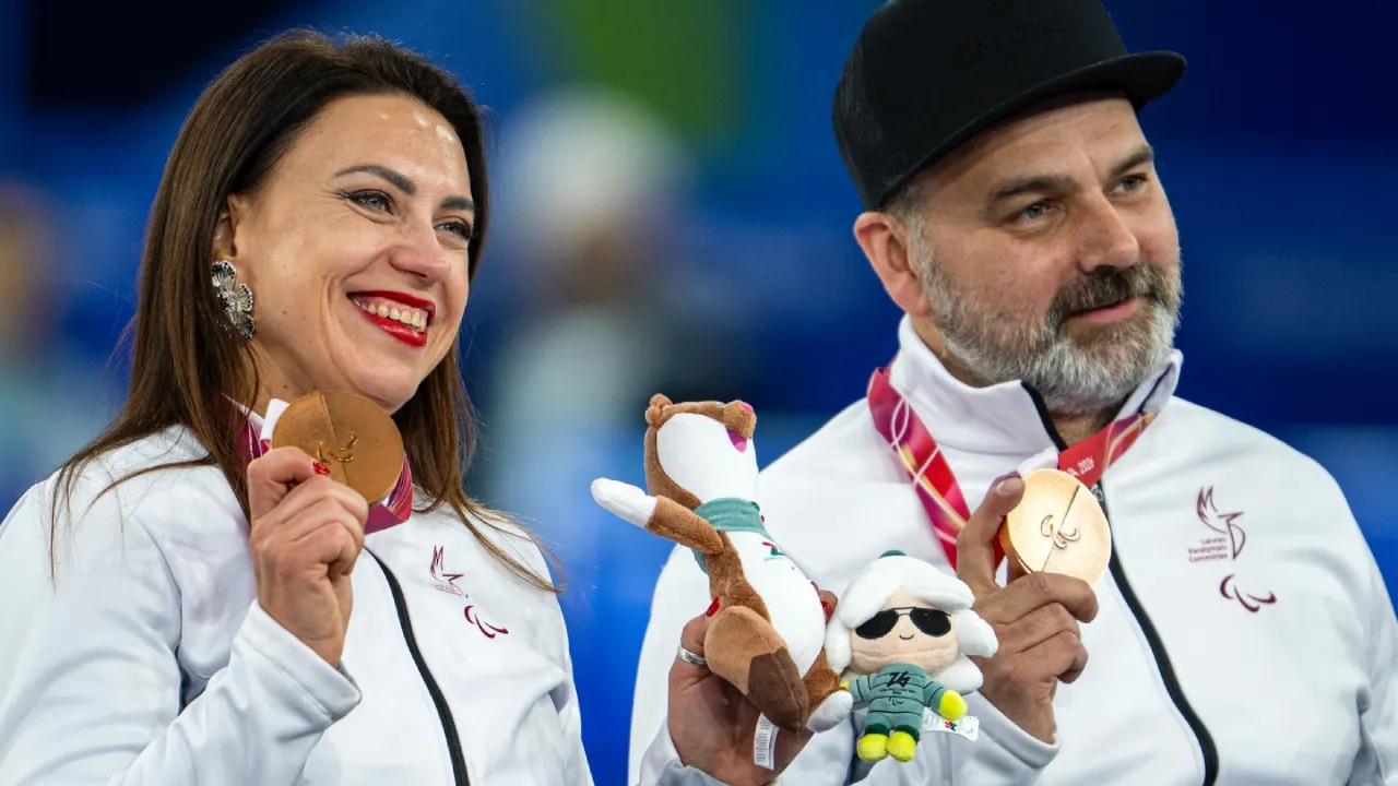Polina Rozkova (kiri) dan Agris Lasmans berpose dengan medali perunggu di Paralimpiade Musim Dingin Milan-Cortina 2026. (Foto: AP)