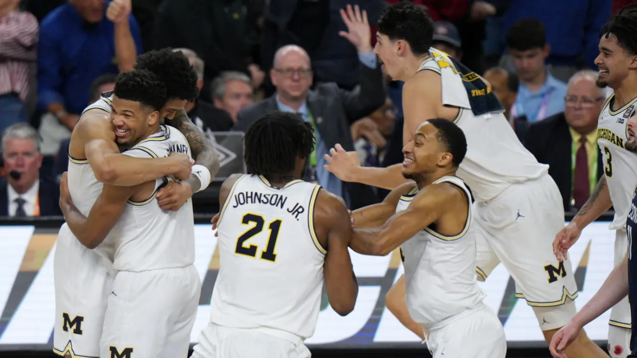 Sirene akhir berbunyi, dan para pemain Michigan Wolverines langsung berlari ke tengah lapangan untuk merayakan keberhasilan bersejarah tersebut. (Foto: AP)